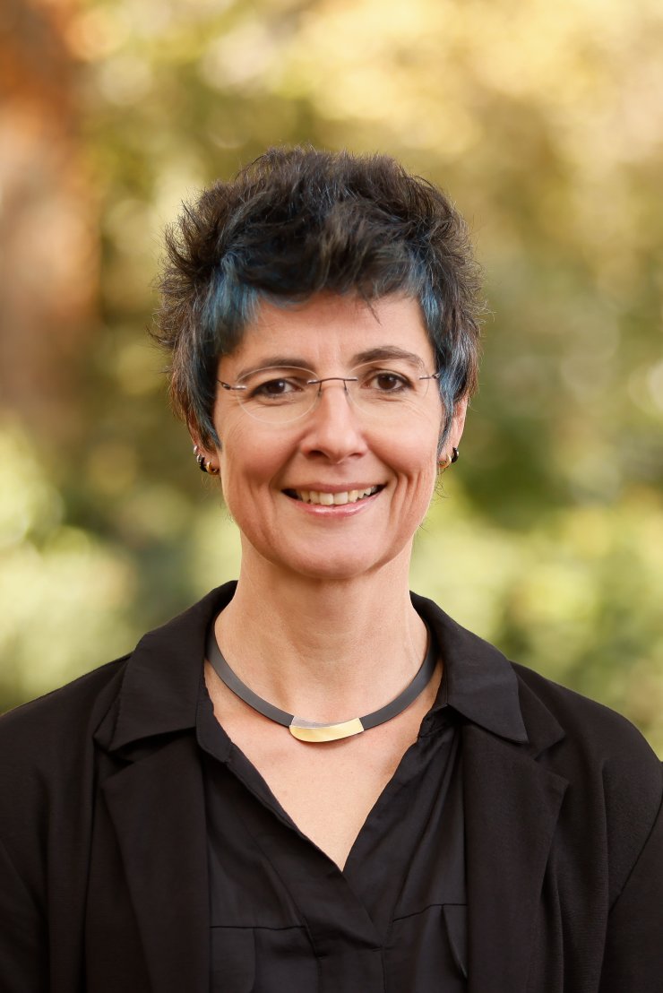 Porträt von Frau Christ mit einem Baum im Hintergrund