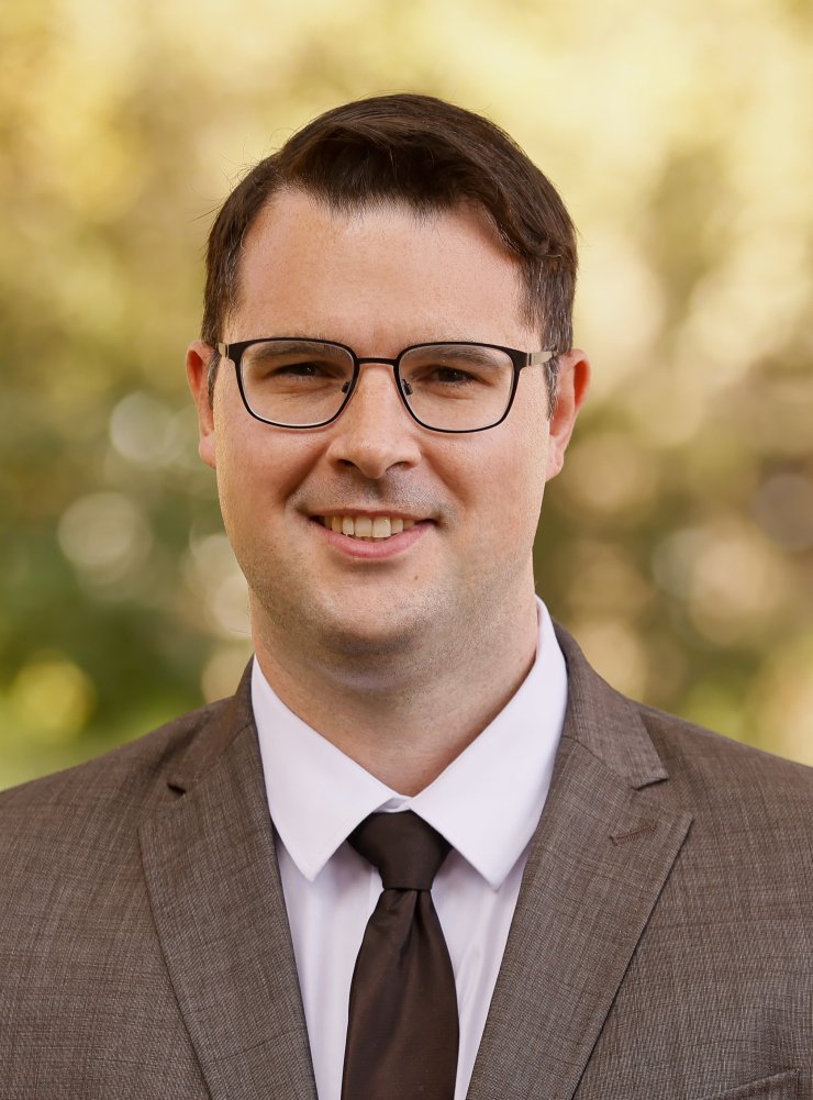 Porträt von Herr Litty mit einem Baum im Hintergrund